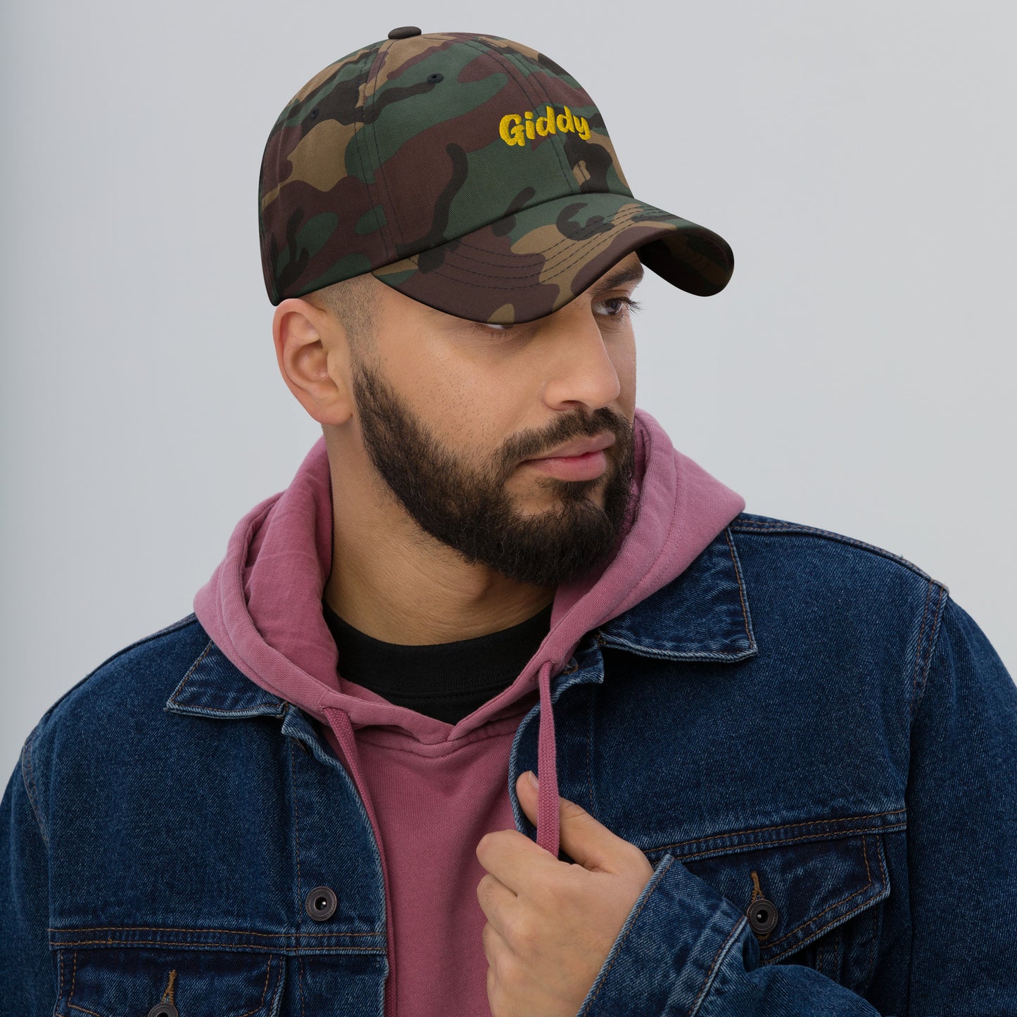 Austin city editions with “Giddy” type in yellow embroidery on camo casual dad hat front view on male model