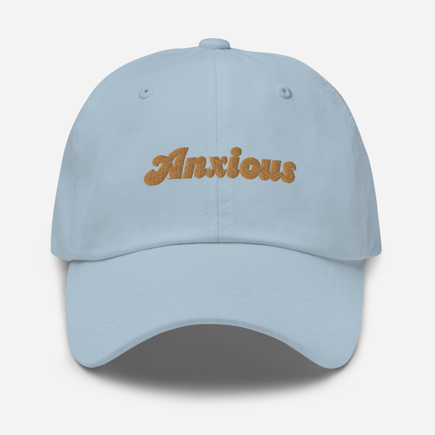 Portland city editions with “Anxious” type in gold embroidery on light blue casual dad hat front view on white background