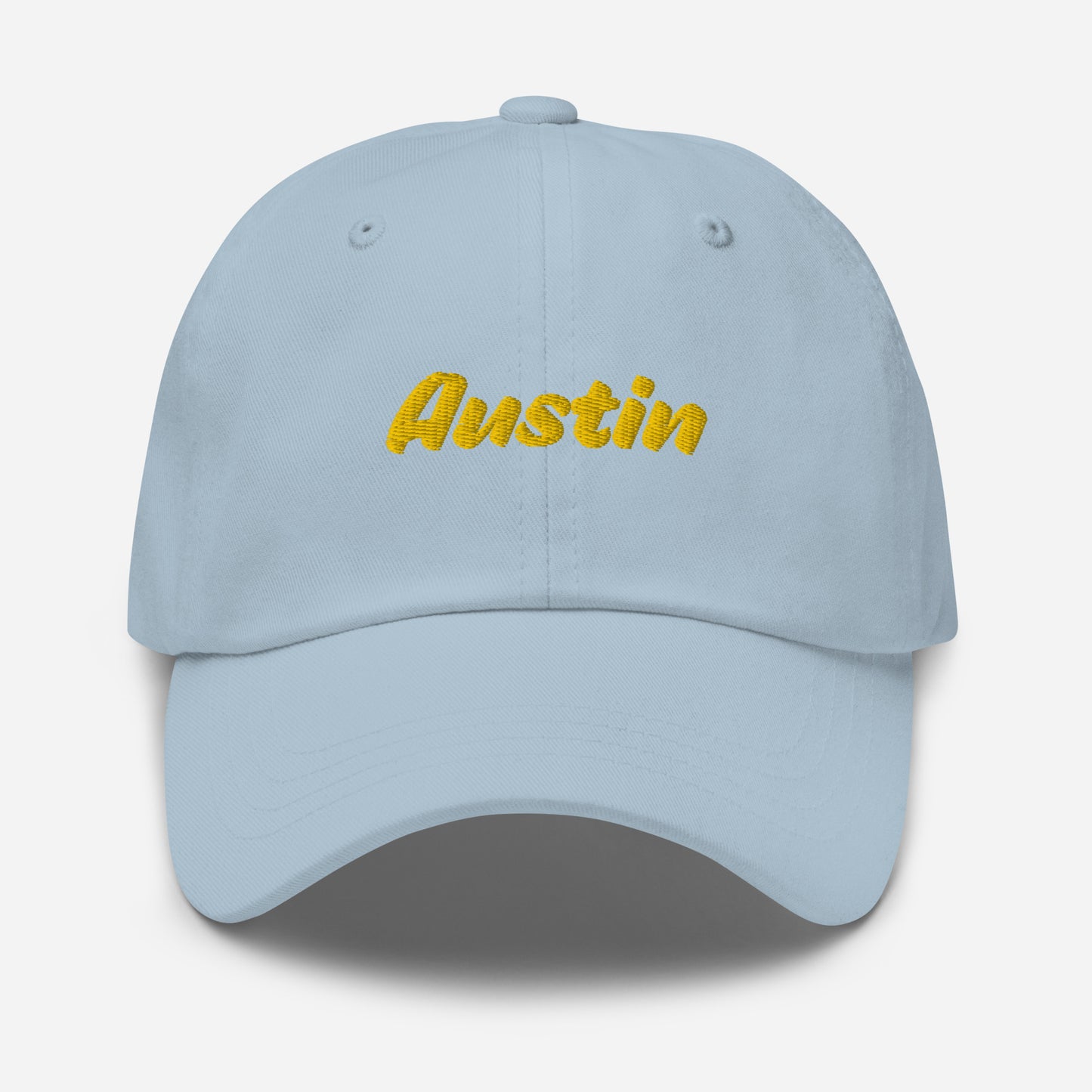 Austin city editions with “Austin” type in yellow embroidery on light blue casual dad hat front view on white background