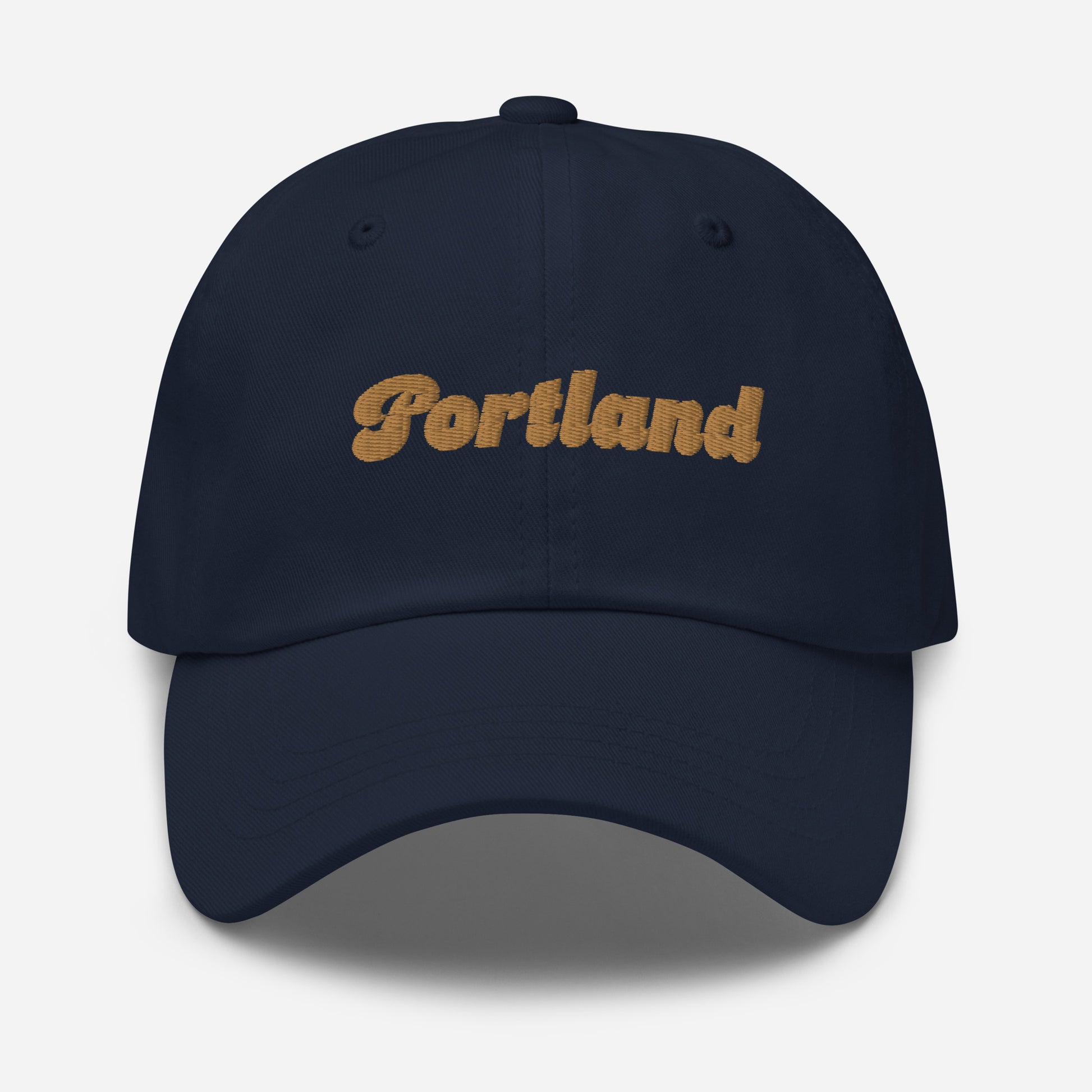 Portland city editions with “Portland” type in gold embroidery on navy casual dad hat front view on white background