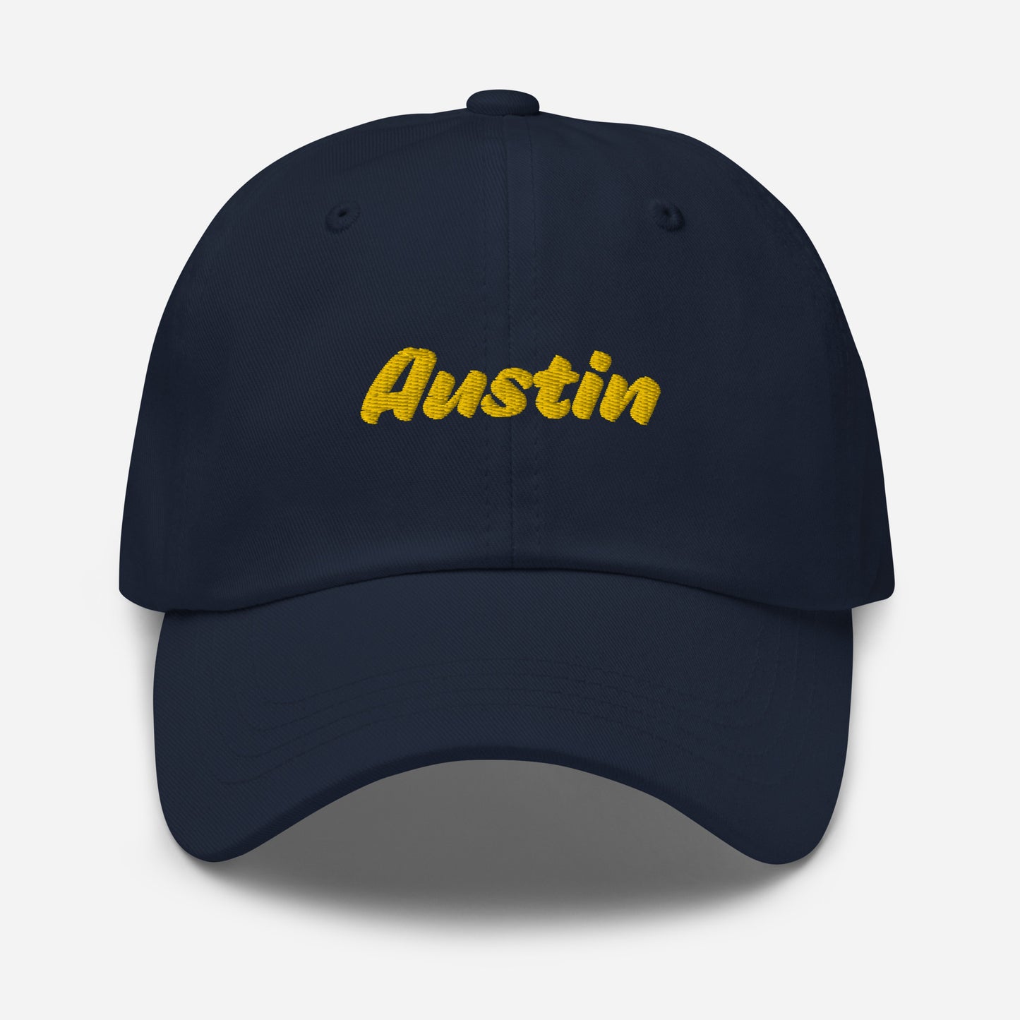 Austin city editions with “Austin” type in yellow embroidery on navy casual dad hat front view on white background