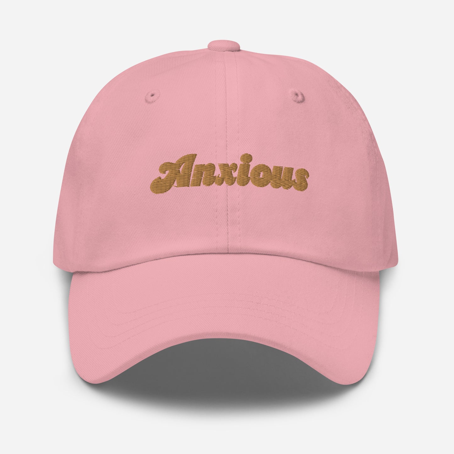 Portland city editions with “Anxious” type in gold embroidery on pink casual dad hat front view on white background