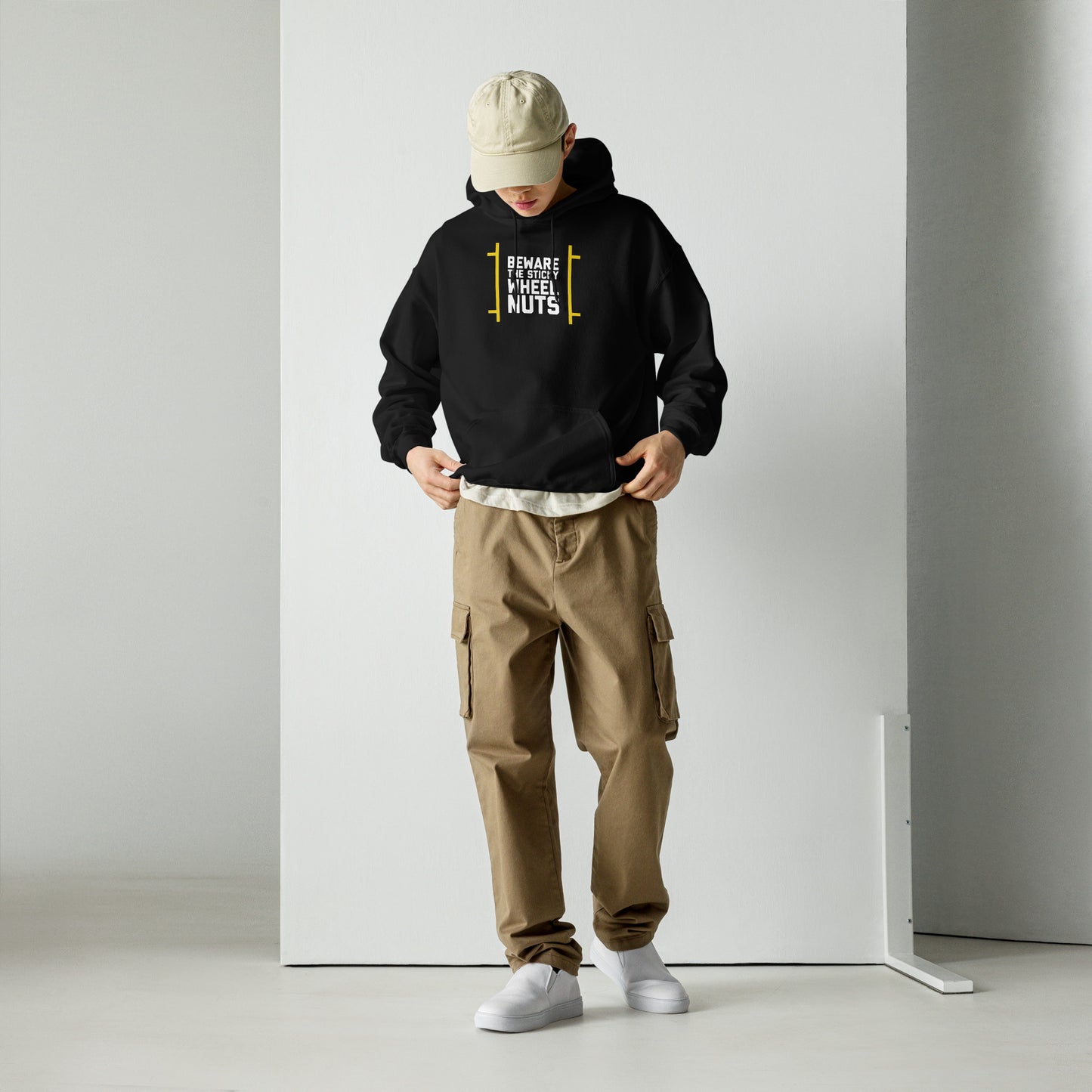 Beware The Sticky Wheel Nuts text on black hoodie, front view on male model looking down