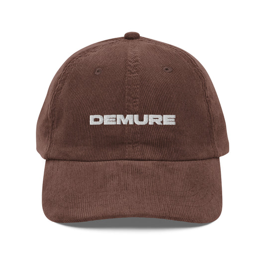 DEMURE, text, type, hat, dad hat, corduroy, cozy, design. front view of brown hat on white background