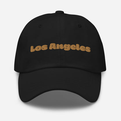 Los Angeles city editions with “Los Angeles” type in gold embroidery on black casual dad hat front view on white background