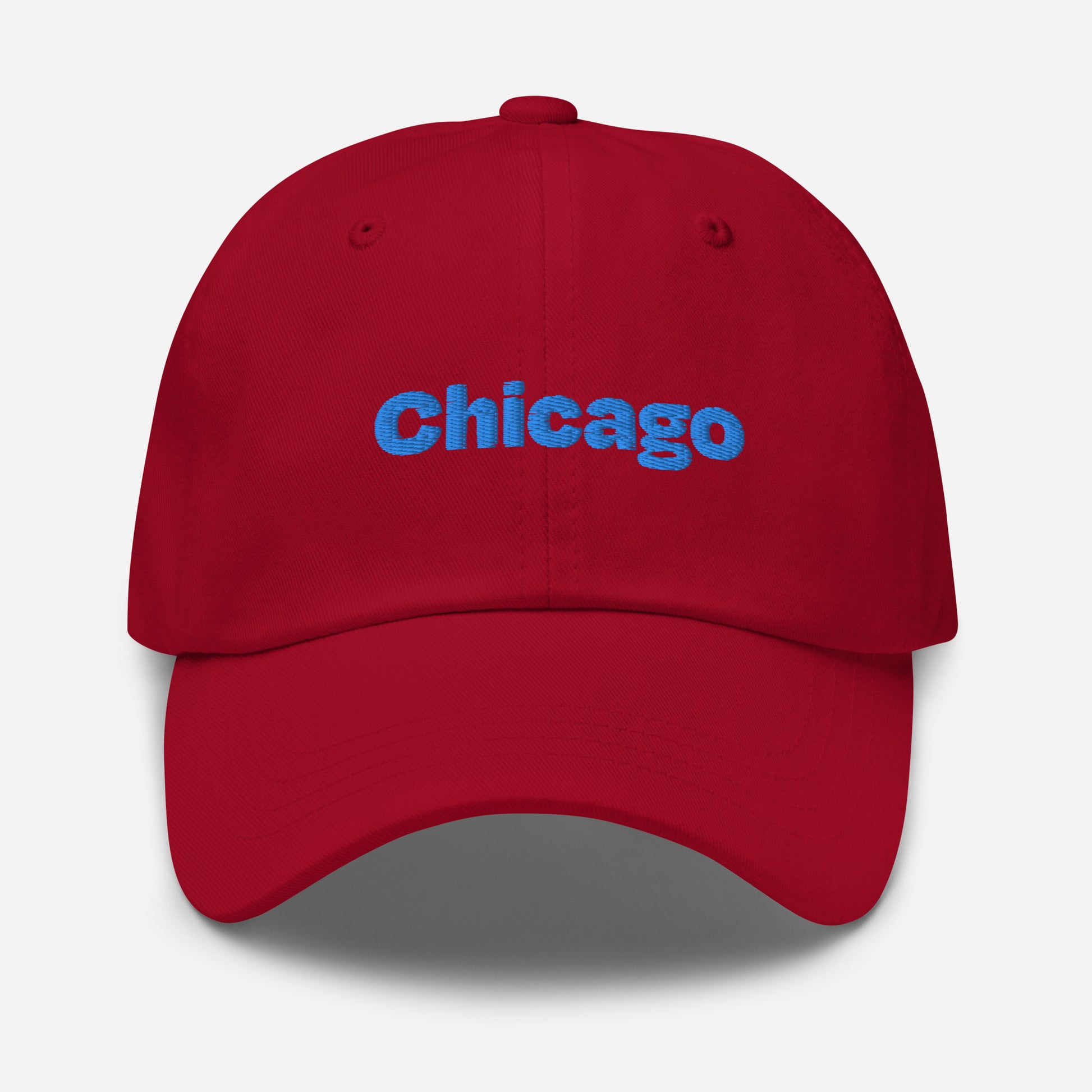 Chicago city editions with “Chicago” type in blue embroidery on red casual dad hat front view on white background