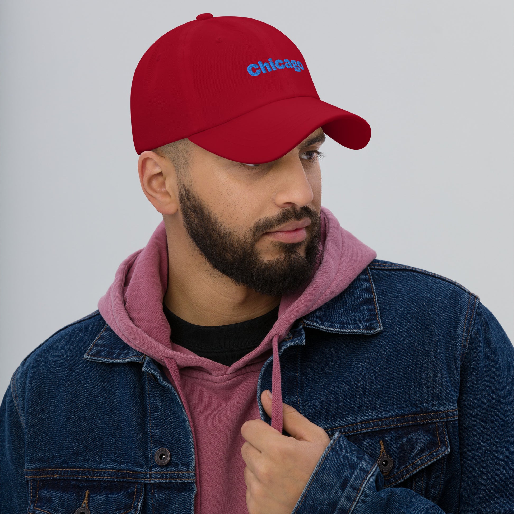 Chicago city editions with “Chicago” type in blue embroidery on red casual dad hat front view on male model