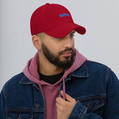 Chicago city editions with “Gritty” type in blue embroidery on red casual dad hat front view on male model