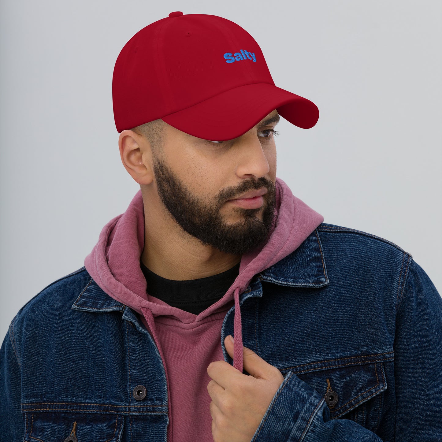 Chicago city editions with “Salty” type in blue embroidery on red casual dad hat front view on male model