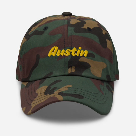 Austin city editions with “Austin” type in yellow embroidery on camo casual dad hat front view on white background