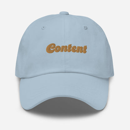 Portland city editions with “Content” type in gold embroidery on light blue casual dad hat front view on white background