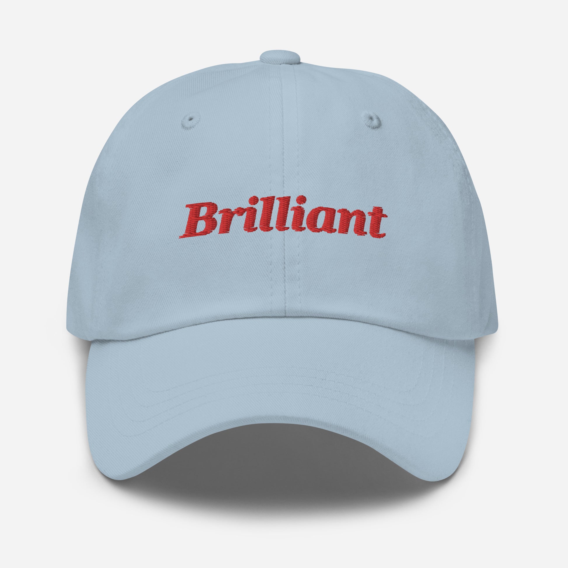 London city editions with “Brilliant” type in red embroidery on light blue casual dad hat front view on white background