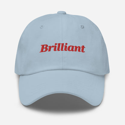 London city editions with “Brilliant” type in red embroidery on light blue casual dad hat front view on white background