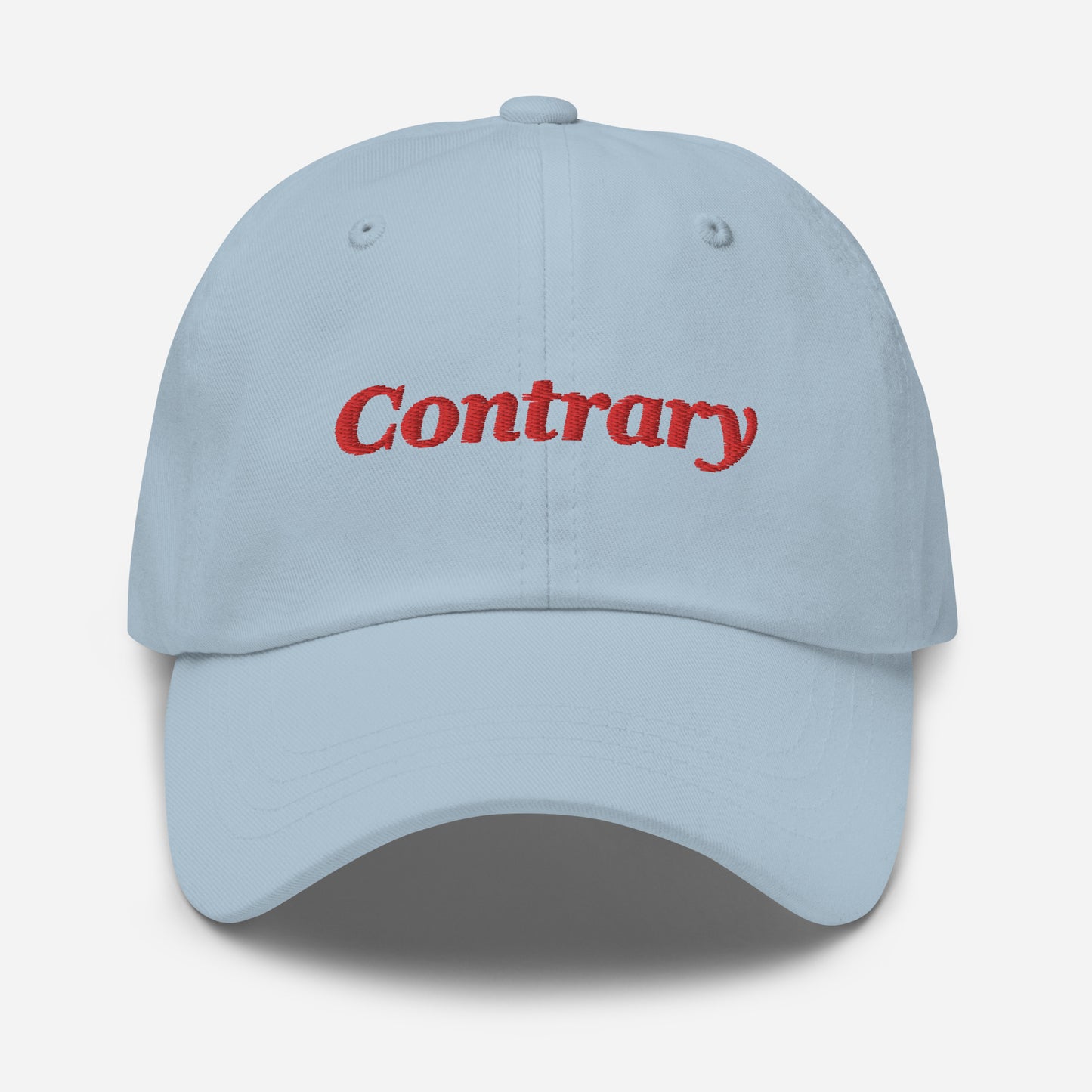 London city editions with “Contrary” type in red embroidery on light blue casual dad hat front view on white background