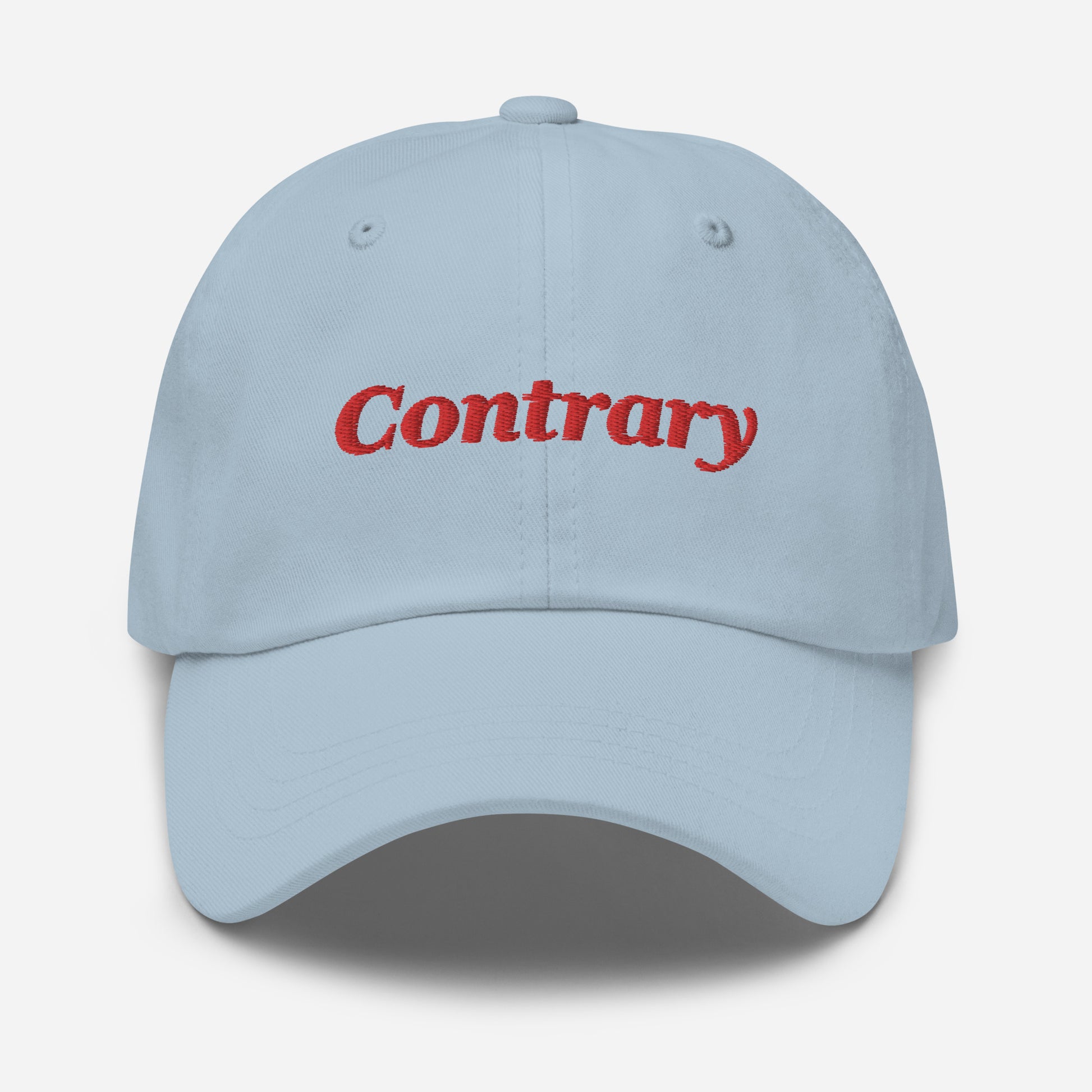 London city editions with “Contrary” type in red embroidery on light blue casual dad hat front view on white background