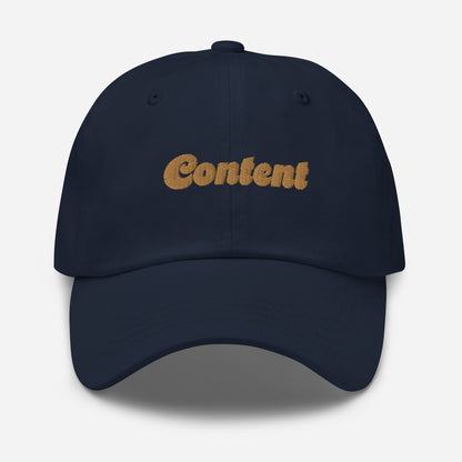 Portland city editions with “Content” type in gold embroidery on navy casual dad hat front view on white background