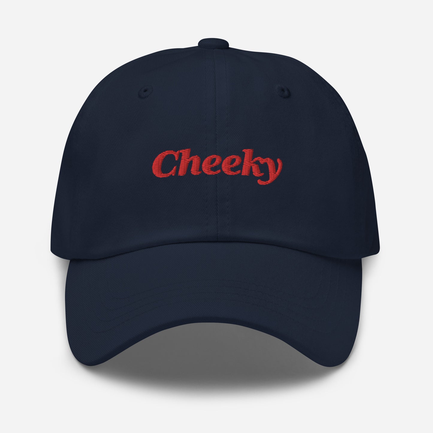 London city editions with “Cheeky” type in red embroidery on navy casual dad hat front view on white background