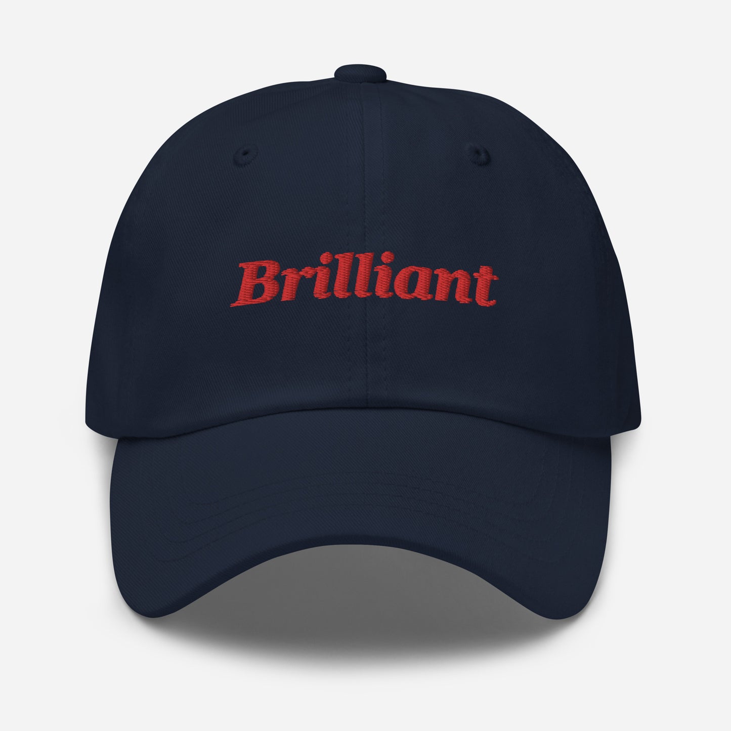 London city editions with “Brilliant” type in red embroidery on navy casual dad hat front view on white background