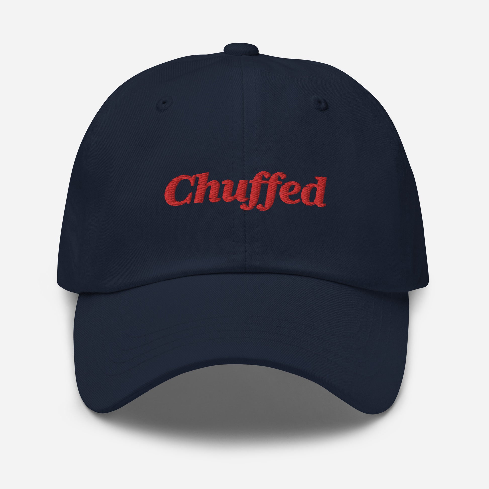 London city editions with “Chuffed” type in red embroidery on navy casual dad hat front view on white background