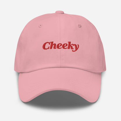 London city editions with “Cheeky” type in red embroidery on pink casual dad hat front view on white background