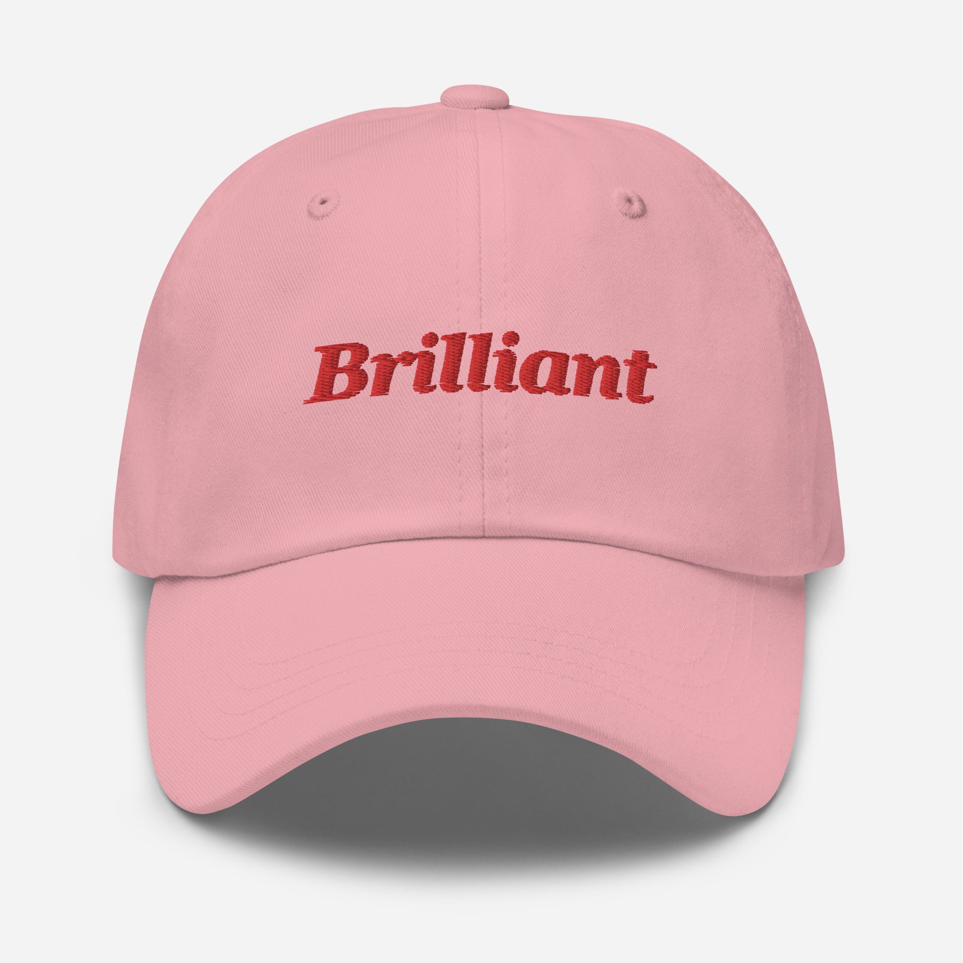 London city editions with “Brilliant” type in red embroidery on pink casual dad hat front view on white background