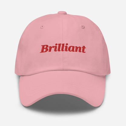 London city editions with “Brilliant” type in red embroidery on pink casual dad hat front view on white background