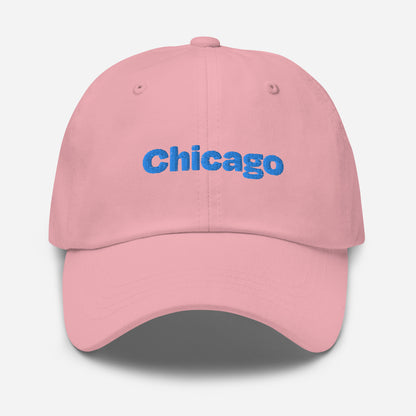 Chicago city editions with “Chicago” type in blue embroidery on pink casual dad hat front view on white background